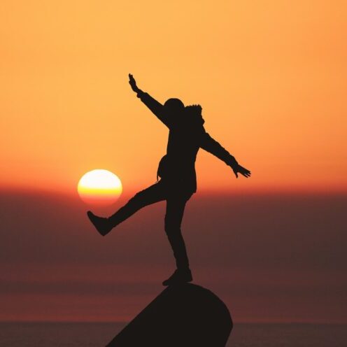 Silhouette of person dancing in sunset