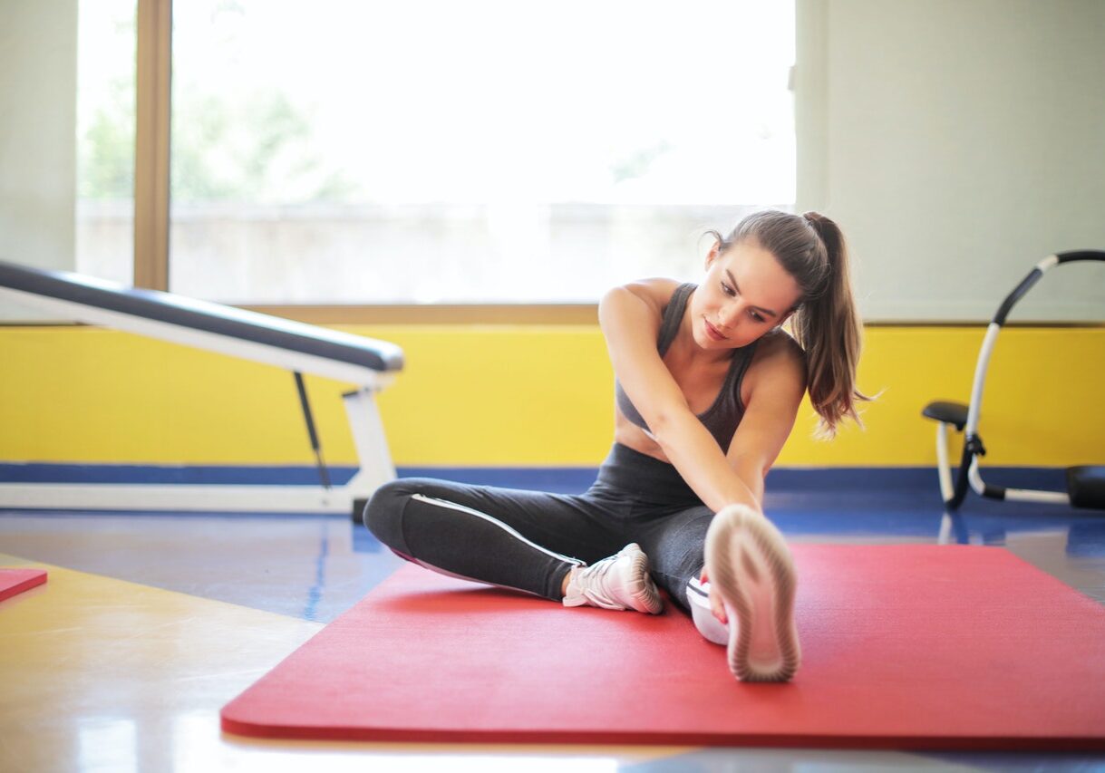 Woman stretching on mat in gym