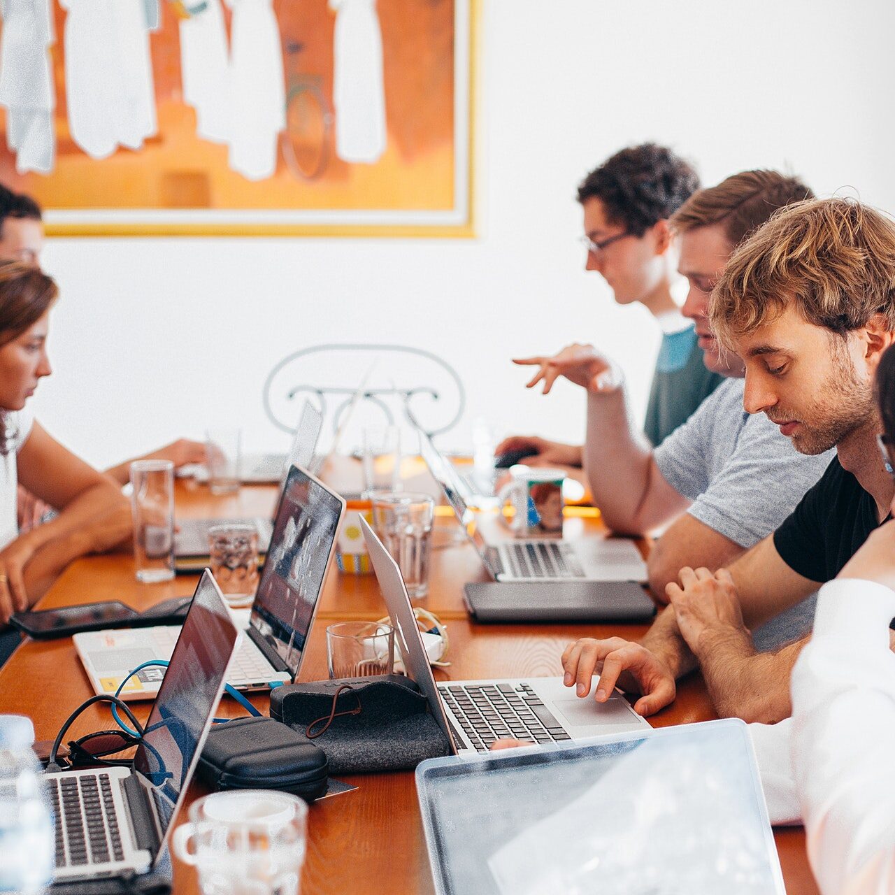 Group of people on their laptops at a conference table