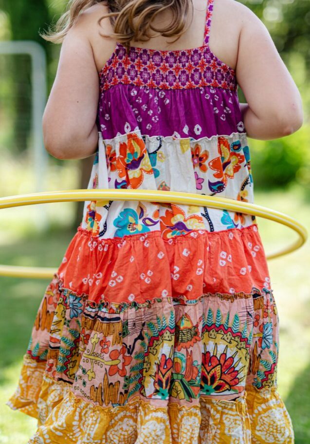 Person in dress hula-hooping outside