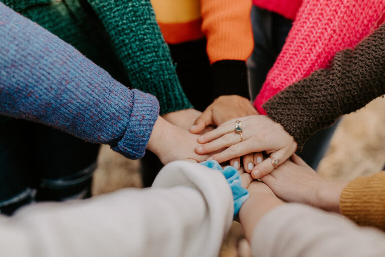 Close up of team in a huddle stacking their hands